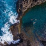 Terwijl je in het rustige water dobbert, spatten een paar meter verder de golfen tegen de rotsen. Natuurlijke baden bij Seixal©Andre Carvalho