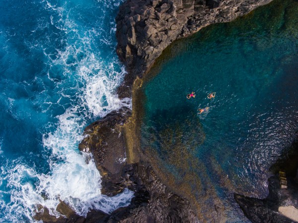 Terwijl je in het rustige water dobbert, spatten een paar meter verder de golfen tegen de rotsen. Natuurlijke baden bij Seixal©Andre Carvalho